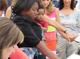 Photo of Shaneka holding her child during her car blessing ceremony